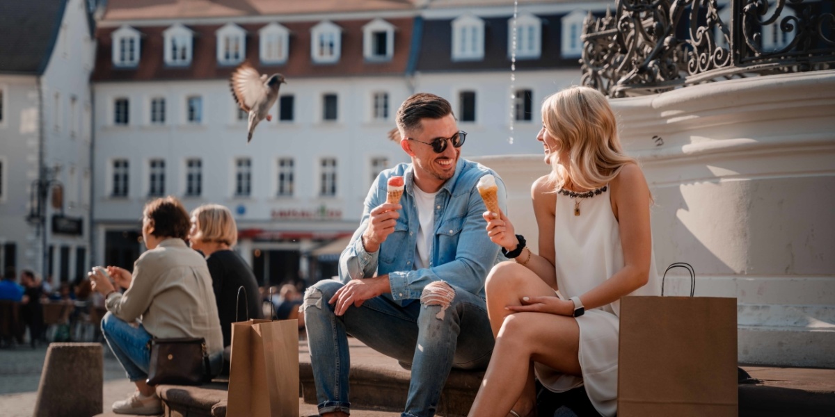 Paar isst Eis während es am Marktbrunnen sitzt
